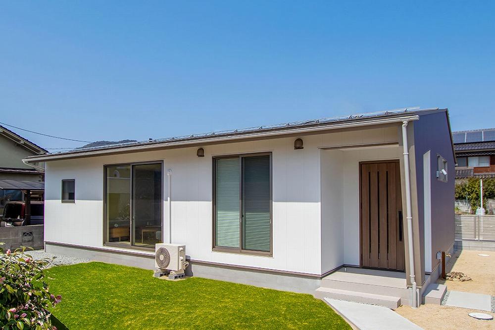 芝生の緑が映える白とグレーパープルでまとめた外観