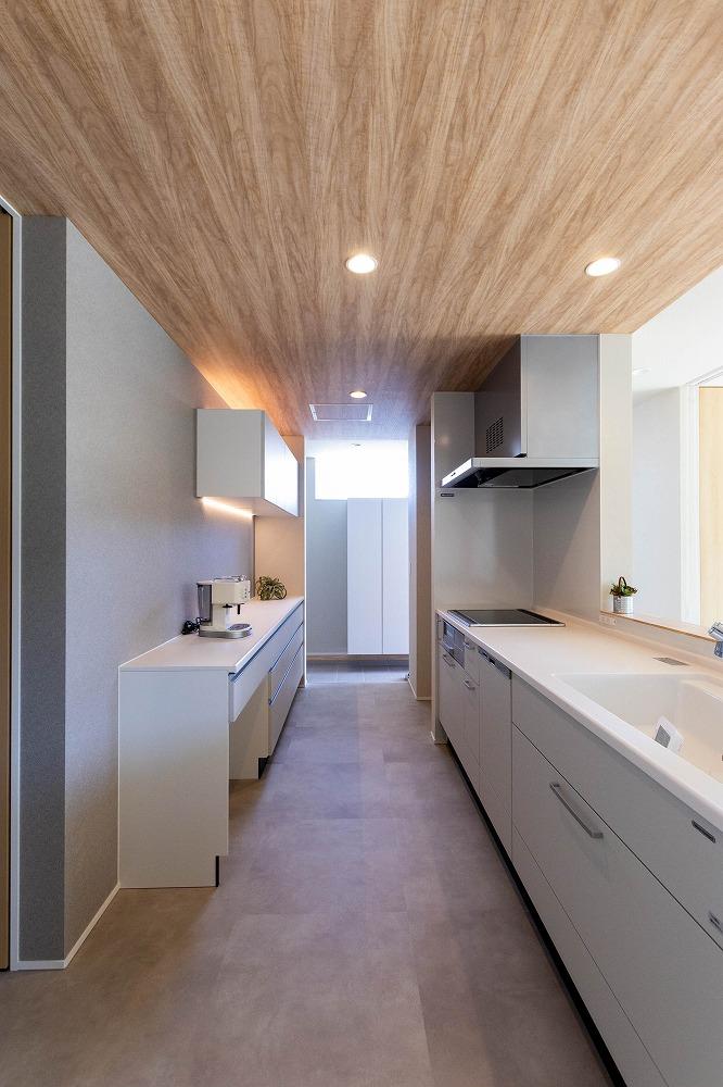 グレーの壁紙と木目天井で温もりと洗練された雰囲気溢れるキッチンに