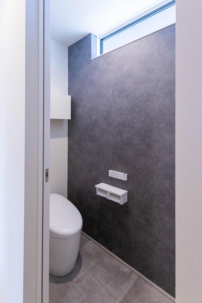 濃いグレーのクロスでモダンと清潔感を感じるトイレに