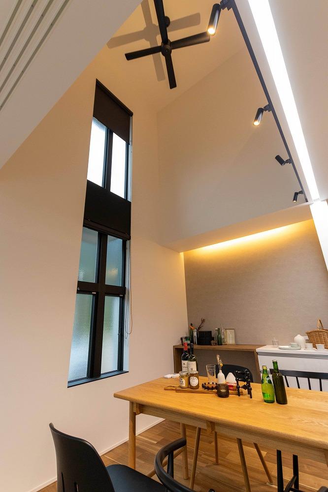 ダイニングの大きな吹き抜け。2階まである縦型の窓から光が差し込む。