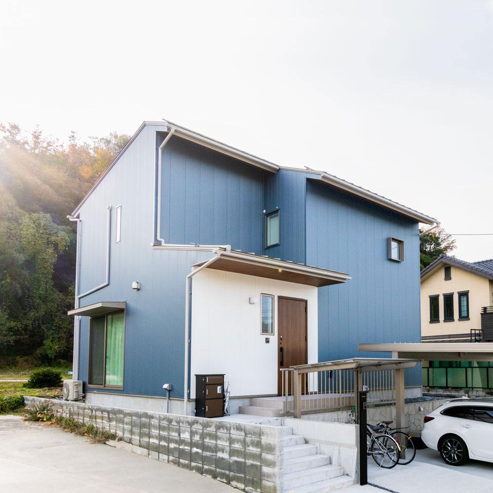 サイドから見た外観。高低差のある敷地を有効活用した駐車場。