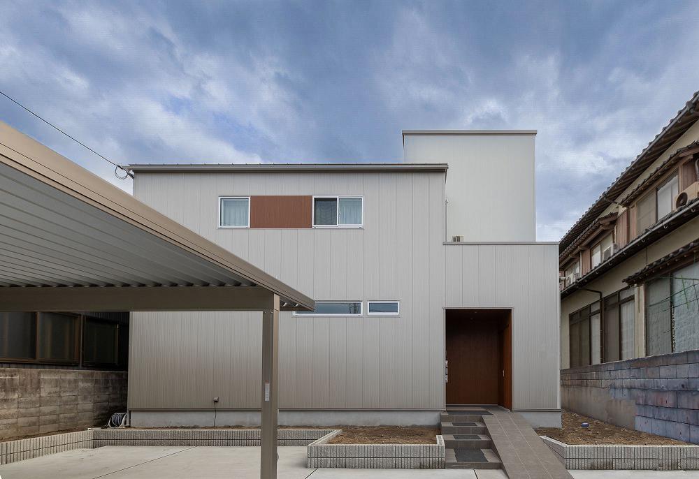 白とグレーのスタイリッシュな外観とカーポート