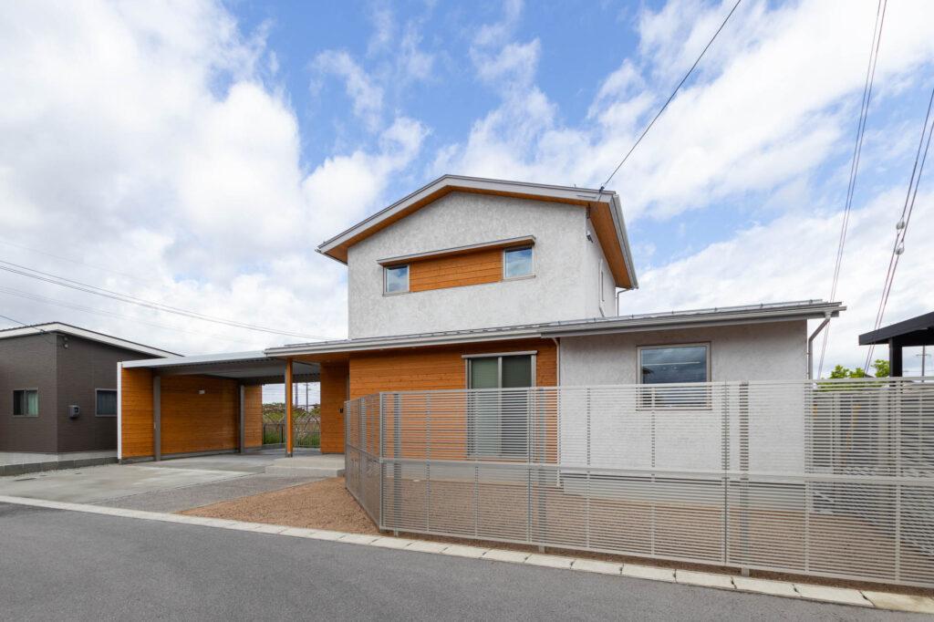 自然素材の塗り壁「そとん壁」を採用。汚れにくく味わい深い質感に、杉板の温もりが調和した外観です。